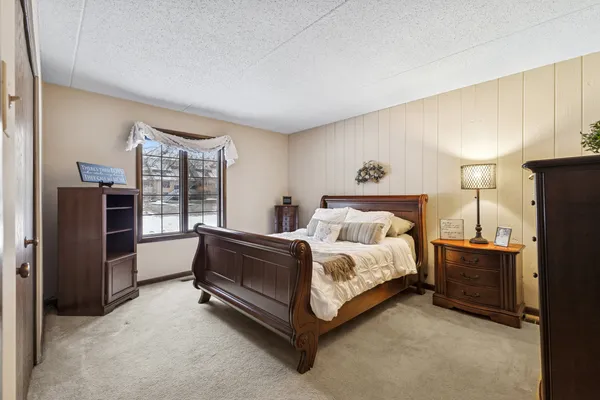 a spacious bedroom with a bed and wooden floor