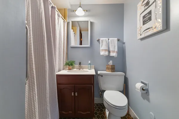 a bathroom with a toilet a sink and mirror