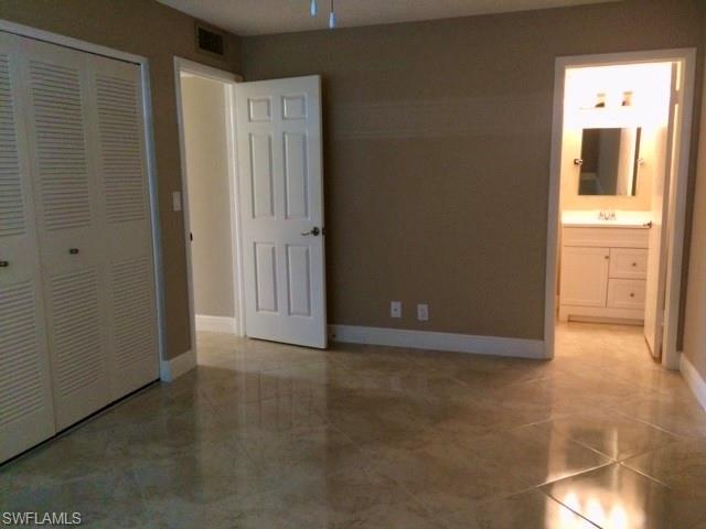 3655 Boca Ciega Drive, Unit 102 Naples, FL 34112 - Photo 12 of 27 a view of a hallway with wooden door