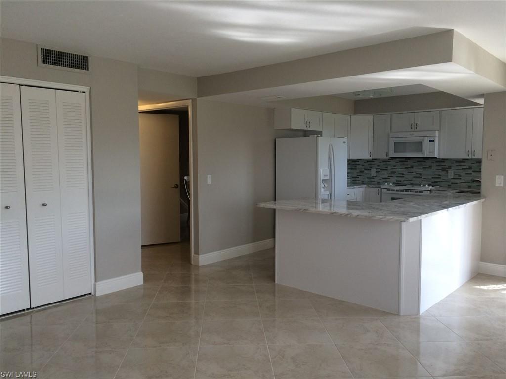 3655 Boca Ciega Drive, Unit 102 Naples, FL 34112 - Photo 15 of 27 a kitchen with stainless steel appliances granite countertop a refrigerator and a sink