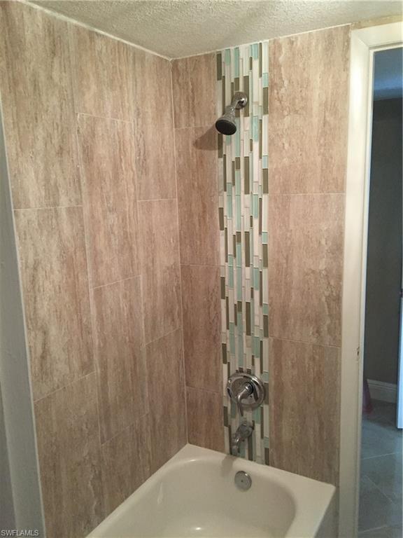 3655 Boca Ciega Drive, Unit 102 Naples, FL 34112 - Photo 17 of 27 a bathroom with a shower and a sink