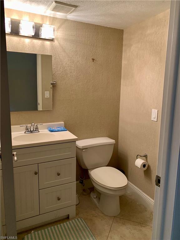 3655 Boca Ciega Drive, Unit 102 Naples, FL 34112 - Photo 18 of 27 a bathroom with a sink a toilet and mirror