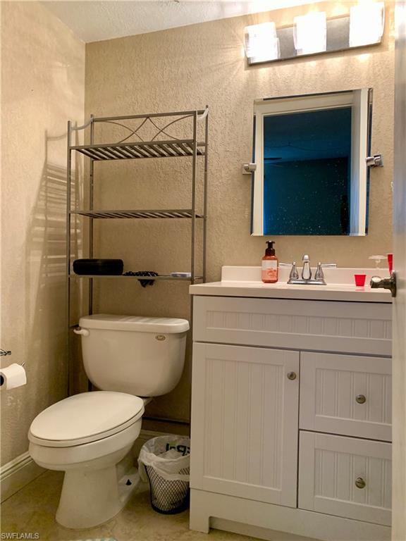 3655 Boca Ciega Drive, Unit 102 Naples, FL 34112 - Photo 19 of 27 a bathroom with a toilet sink and mirror