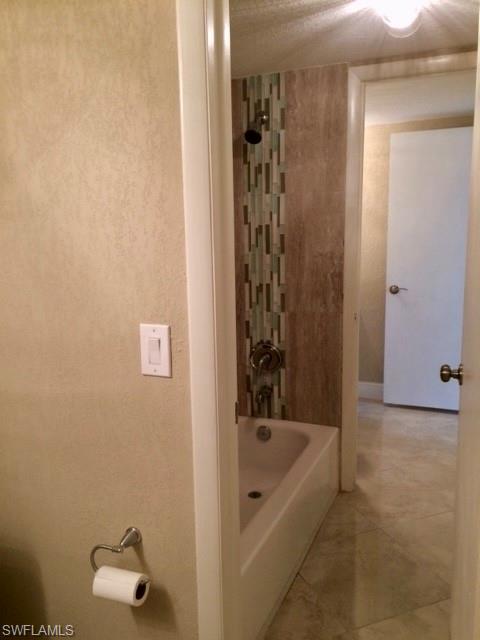 3655 Boca Ciega Drive, Unit 102 Naples, FL 34112 - Photo 20 of 27 a bathroom with a bathtub and shower