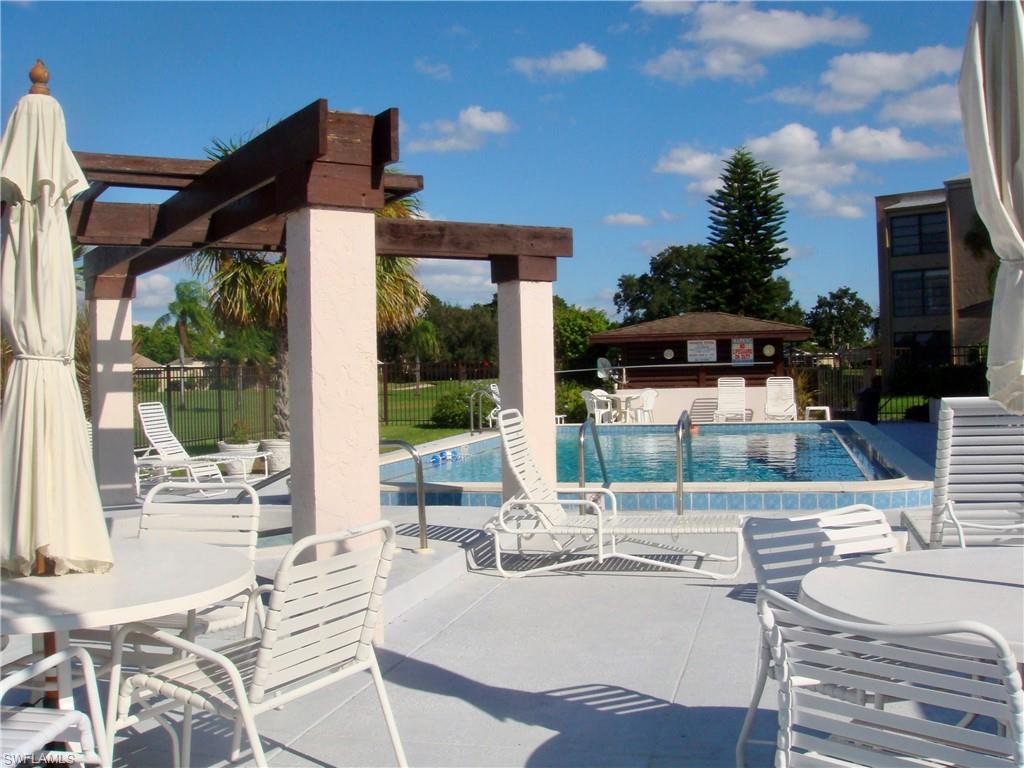 3655 Boca Ciega Drive, Unit 102 Naples, FL 34112 - Photo 24 of 27 a patio with yard glass top table and chairs