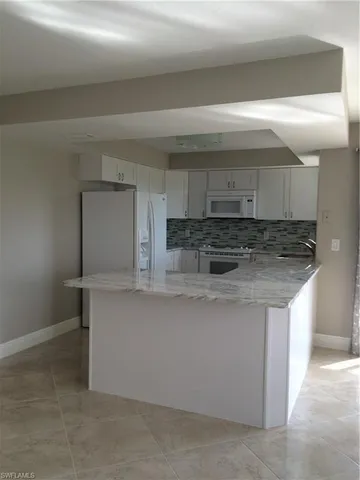 a kitchen with stainless steel appliances granite countertop a sink and a stove