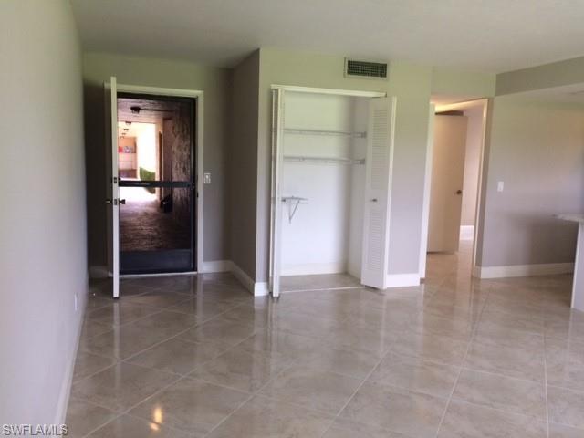 3655 Boca Ciega Drive, Unit 102 Naples, FL 34112 - Photo 9 of 27 a view of a hallway with wooden shelves