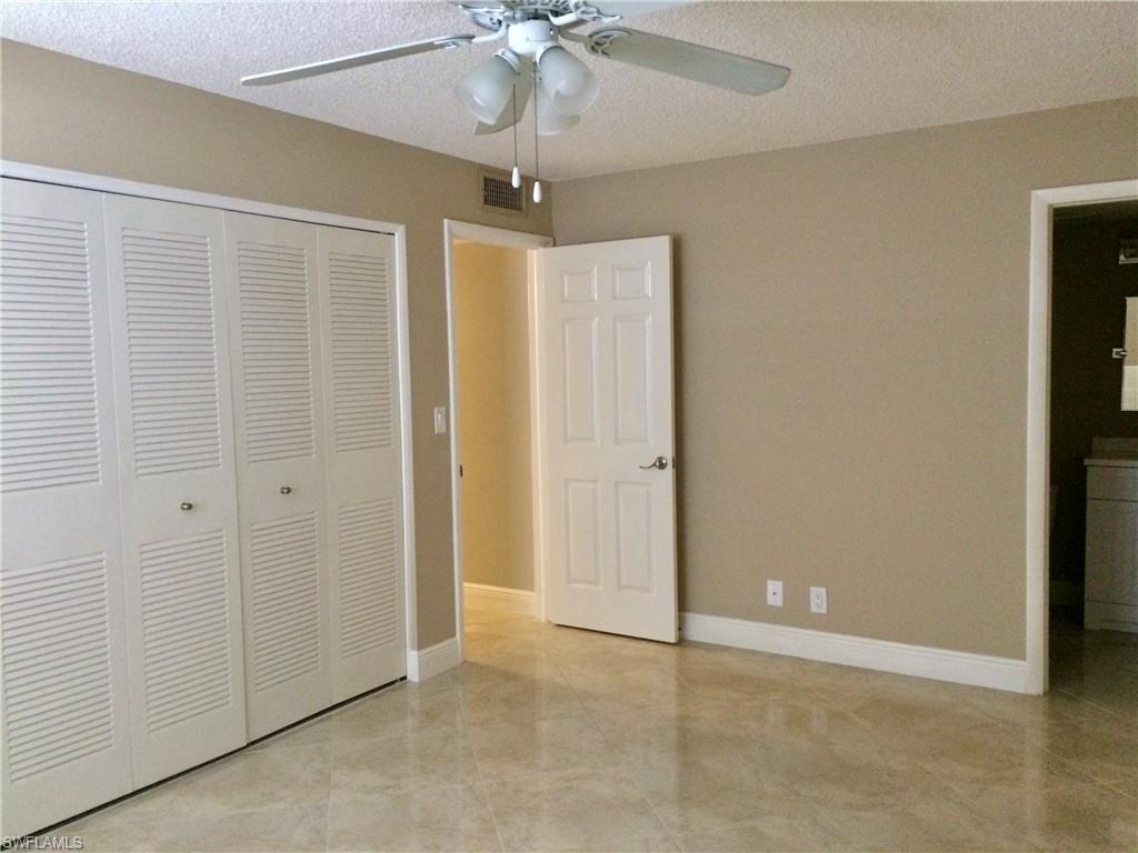 3655 Boca Ciega Drive, Unit 102 Naples, FL 34112 - Photo 10 of 27 an empty room with a ceiling fan and a window
