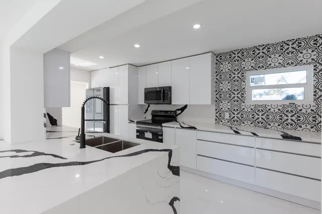 a kitchen with stainless steel appliances kitchen island a sink stove and refrigerator