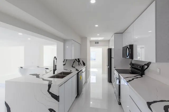 a kitchen with stainless steel appliances a sink stove and refrigerator