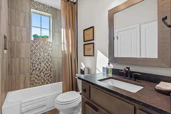 a bathroom with a granite countertop sink toilet and shower