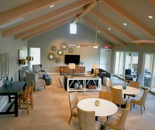 a living room with furniture a flat screen tv and kitchen view