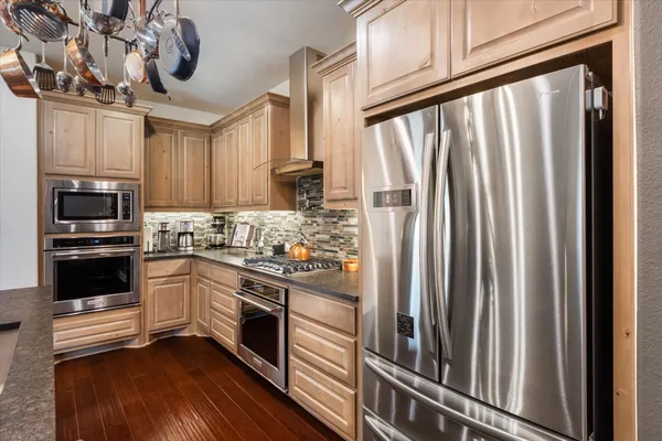 a kitchen with stainless steel appliances a refrigerator sink and microwave