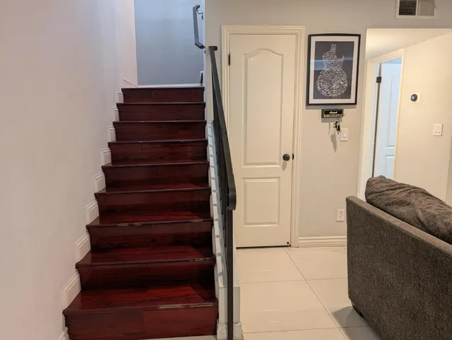 a view of a hallway with stairs and furniture