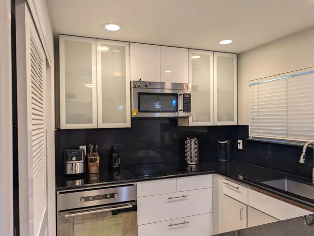 a kitchen with granite countertop a refrigerator and a sink