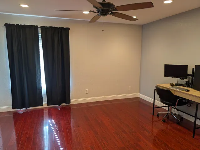 a view of a workspace with furniture and wooden floor