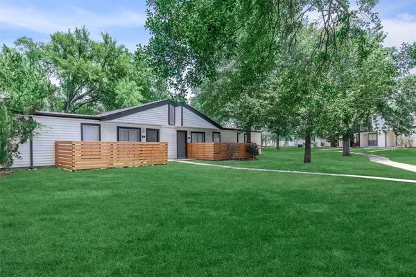 a view of a house with a big yard and large trees