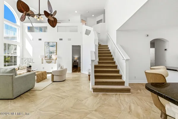 a living room with furniture large window and glass door
