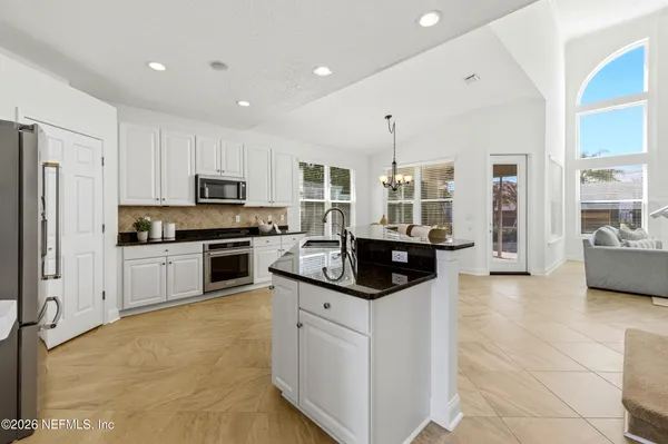 a kitchen with granite countertop a sink a stove and refrigerator