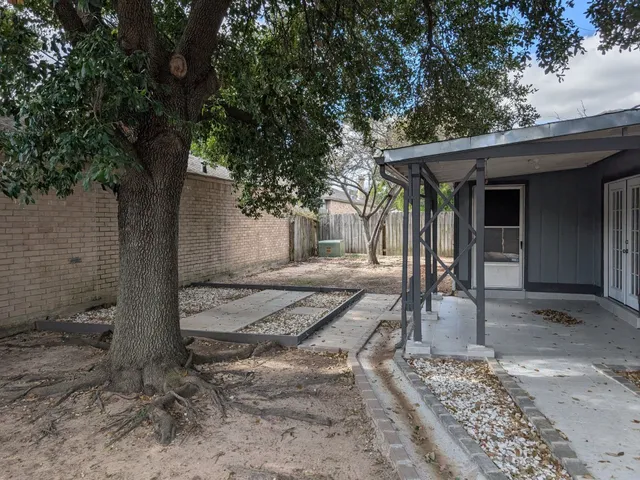 a view of a house with backyard and trees