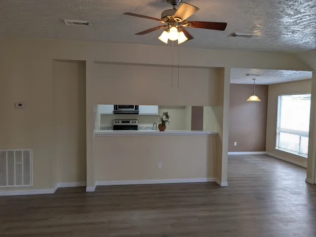 a view of a kitchen with wooden floor and a ceiling fan