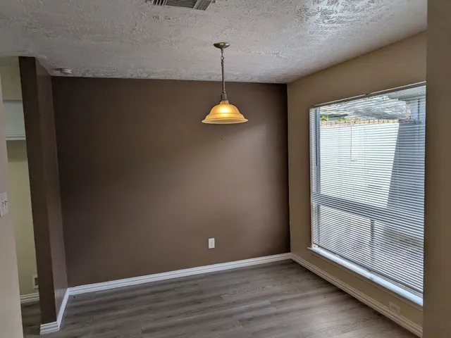 a view of a room with wooden floor and window
