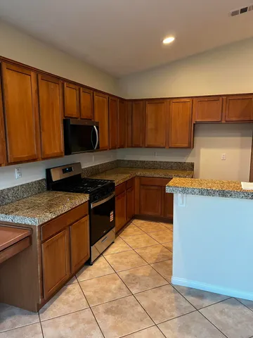 a kitchen with stainless steel appliances granite countertop a stove a sink and a microwave