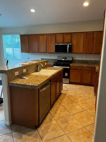a kitchen with stainless steel appliances granite countertop a sink stove and cabinets