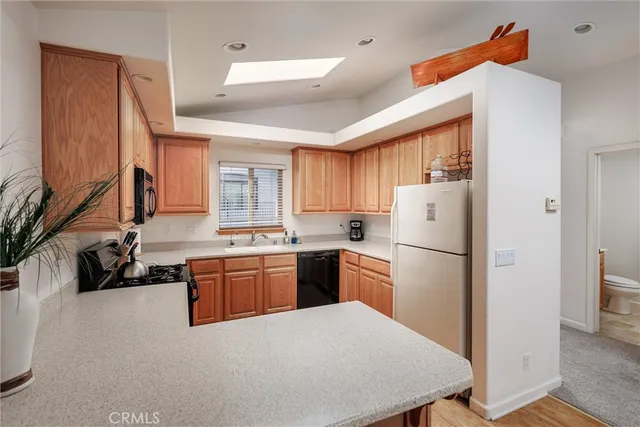a kitchen with refrigerator a sink a stove and cabinets