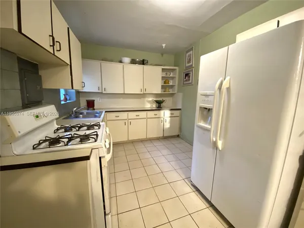 a kitchen with a refrigerator sink stove and cabinets