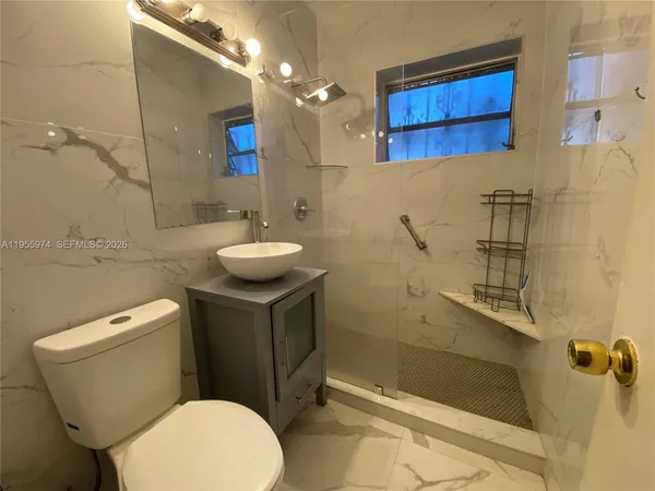 a bathroom with a toilet a sink and mirror