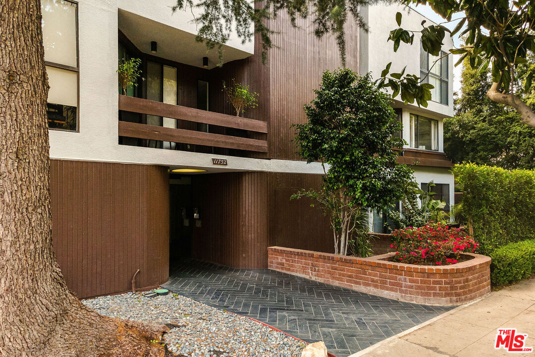 a view of a house with a potted plant and a tree