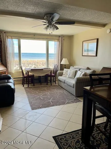 a living room with patio furniture and a floor to ceiling window