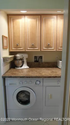 a kitchen with granite countertop a sink and a white wooden cabinets