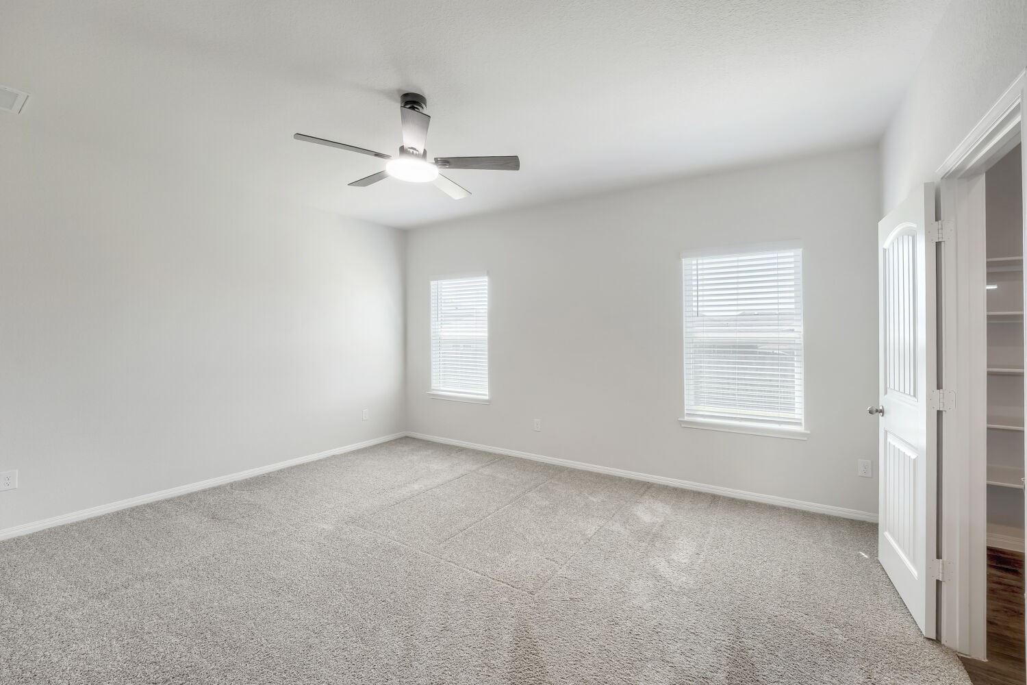 13507 Howser Trace Manor, TX 78653 - Photo 11 of 28 The carpeted bedroom offers abundant natural illumination through two large windows, ensuring a serene and comfortable living space.