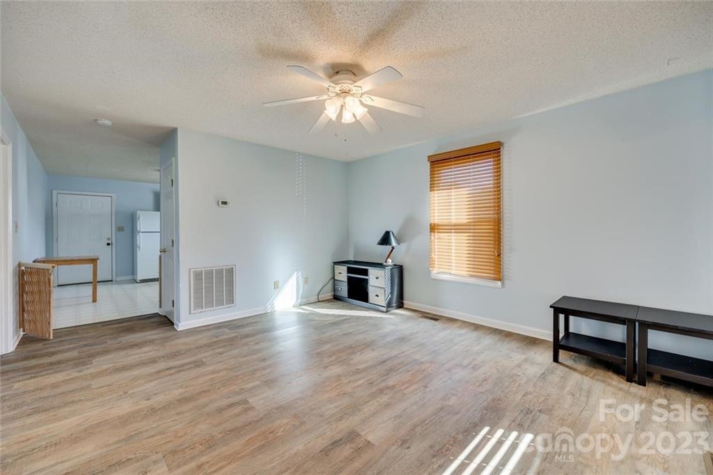 203 Brook Street Belmont, NC 28012 - Photo 7 of 17 a view of a livingroom with wooden floor and a ceiling fan