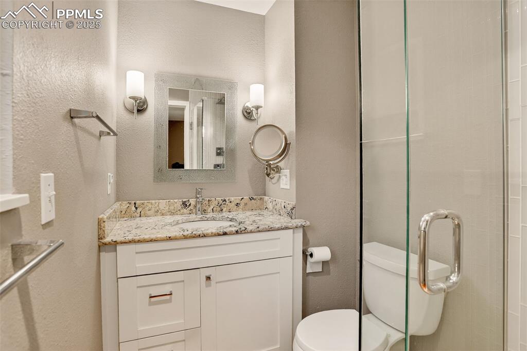 6035 Tuckerman Lane Colorado Springs, CO 80918 - Photo 25 of 47 a bathroom with a toilet sink and mirror