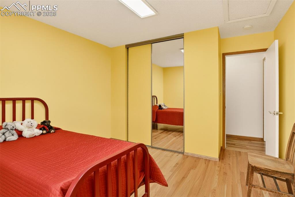6035 Tuckerman Lane Colorado Springs, CO 80918 - Photo 26 of 47 a bedroom with a bed and wooden floor