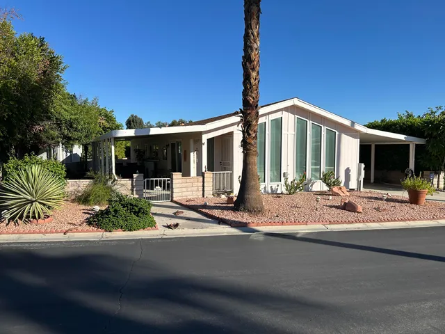 a front view of a house with garden and patio