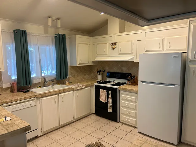 a kitchen with stainless steel appliances a refrigerator sink and cabinets