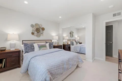 a spacious bedroom with a bed and a lamp
