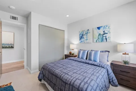 a bedroom with a bed and painting on the wall