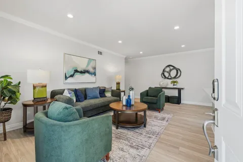 a living room with furniture and a wooden floor