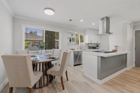 a kitchen with a dining table chairs and white cabinets