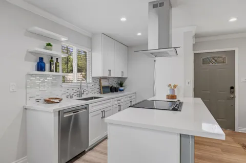 a kitchen with a sink a stove and cabinets