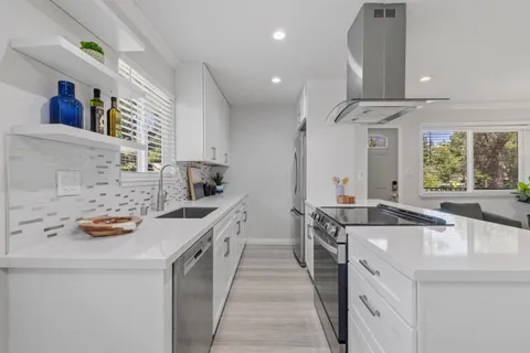 a kitchen with stainless steel appliances a sink stove and cabinets