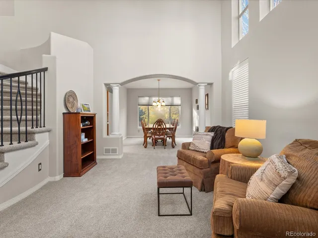 a dining room with furniture a chandelier and window