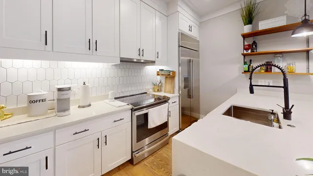 a kitchen with stainless steel appliances granite countertop white cabinets and a stove