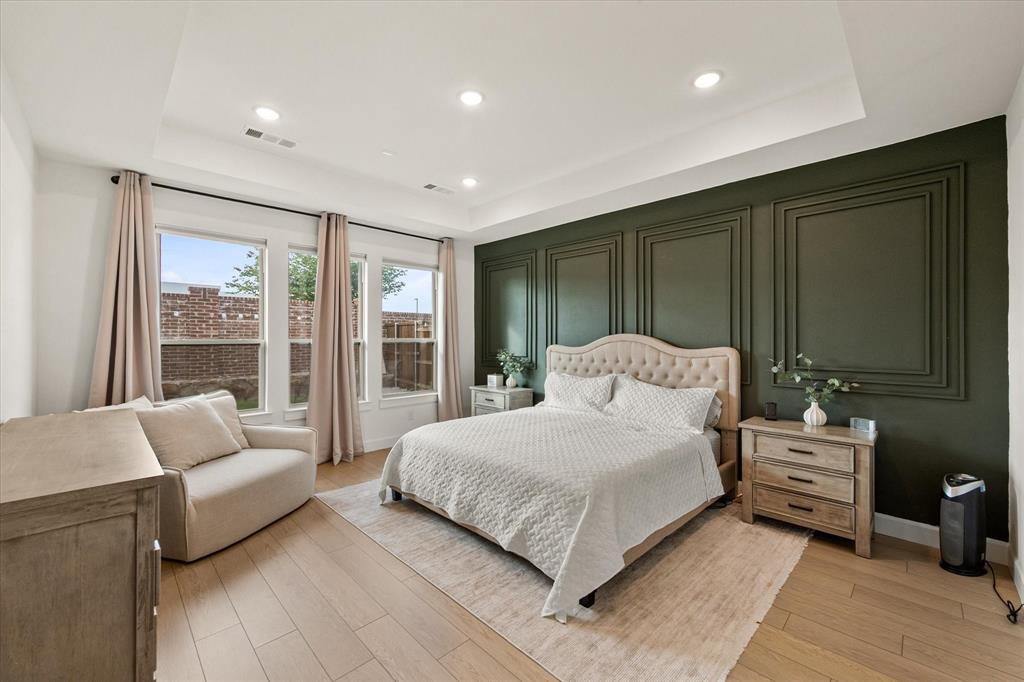 208 Scottish Way Mansfield, TX 76063 - Photo 20 of 38 Bedroom with a feature wall, LVP, and a tray ceiling!