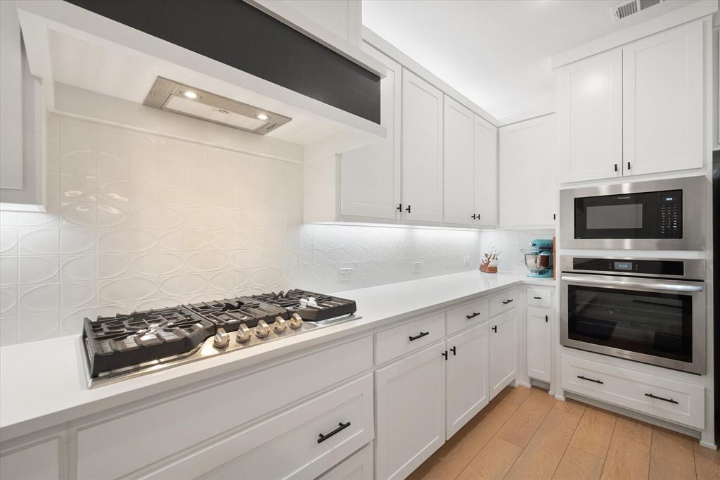 208 Scottish Way Mansfield, TX 76063 - Photo 8 of 38 Kitchen with white cabinetry, stainless steel appliances & recessed lighting!